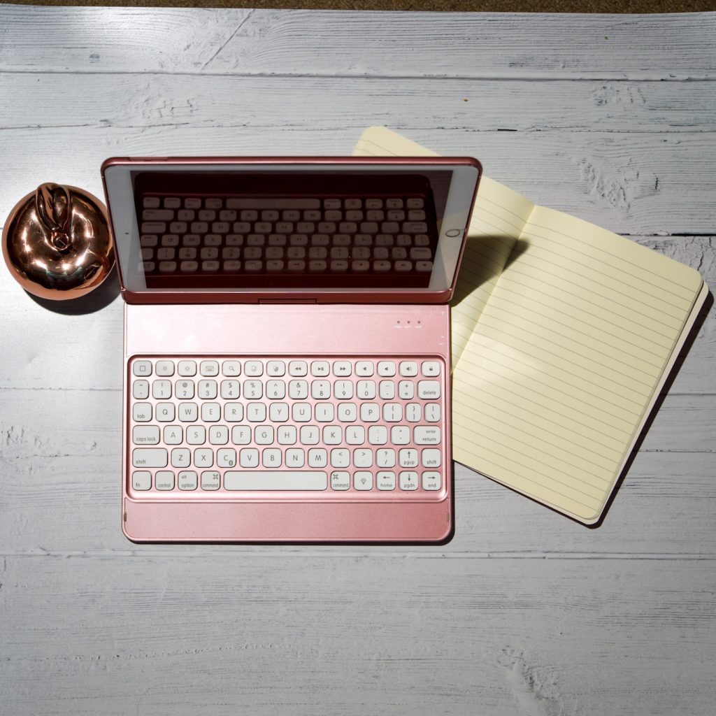 Support your mental wellbeing whilst at work.  Image is of a flat lay of a laptop and notebook