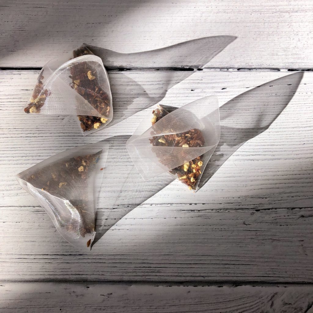 I'm not Ok, and that's Ok. Flat lay image of three teabags on a cream wood surface